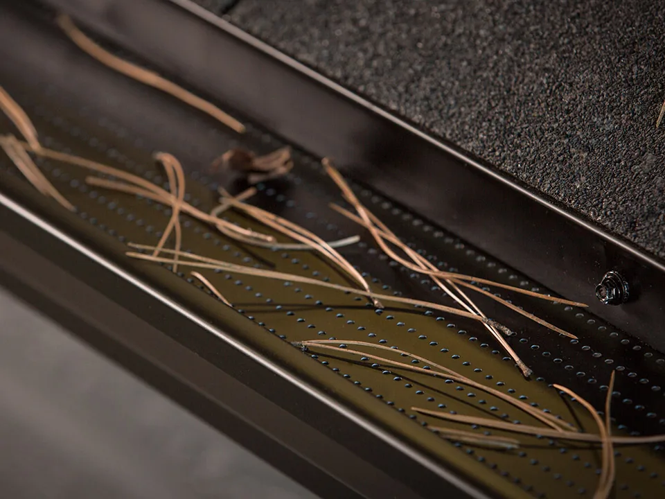 Pine needles resting above DoublePro gutter protection