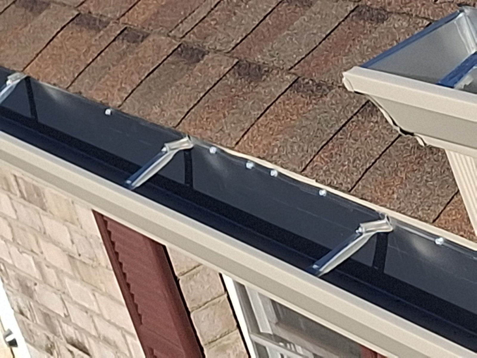 Field example showing extra fasteners and patchwork at a roof-edge detail on a system not installed by McCloud Gutter.
